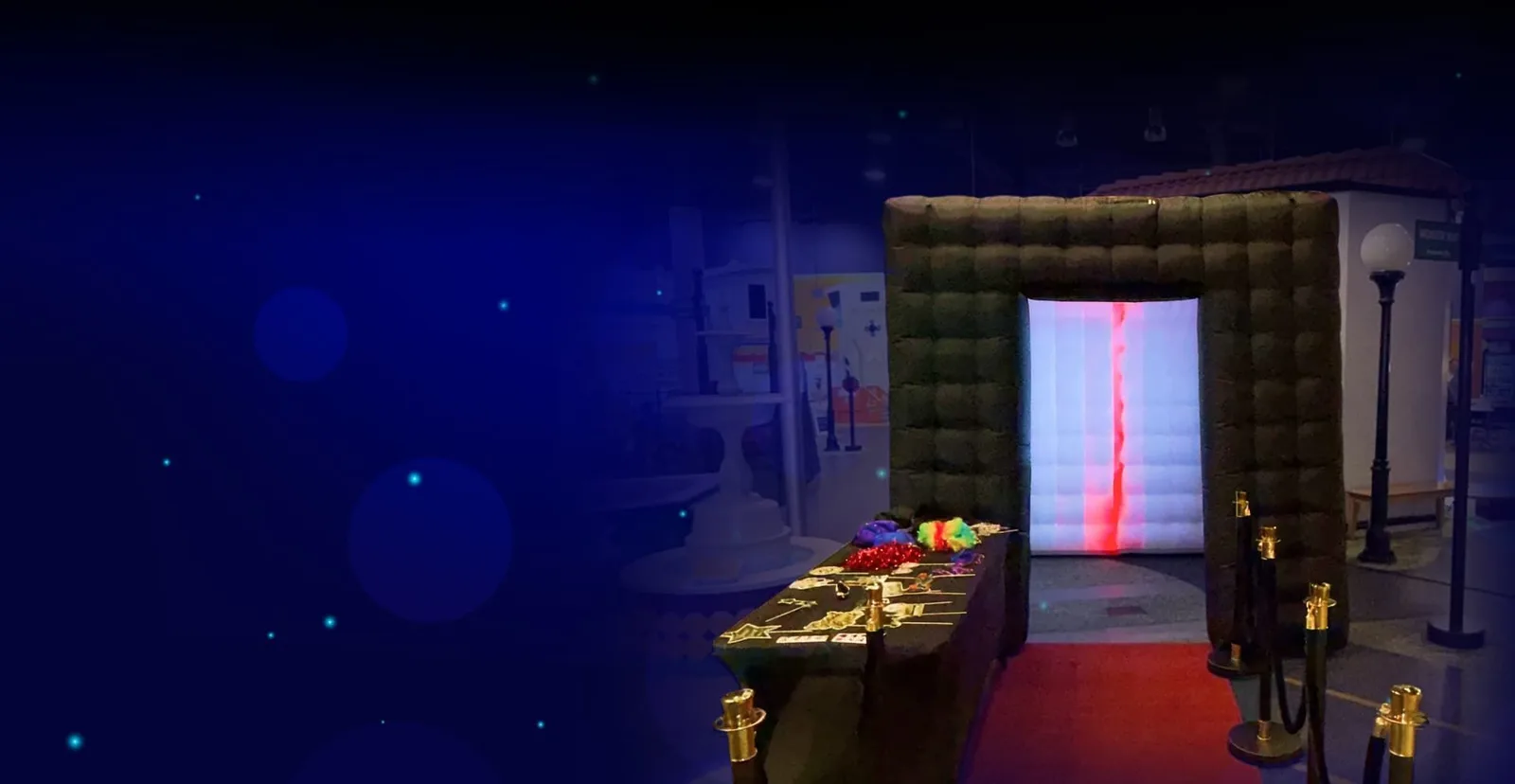 Enclosed photo booth in a blue-lit venue with red carpet