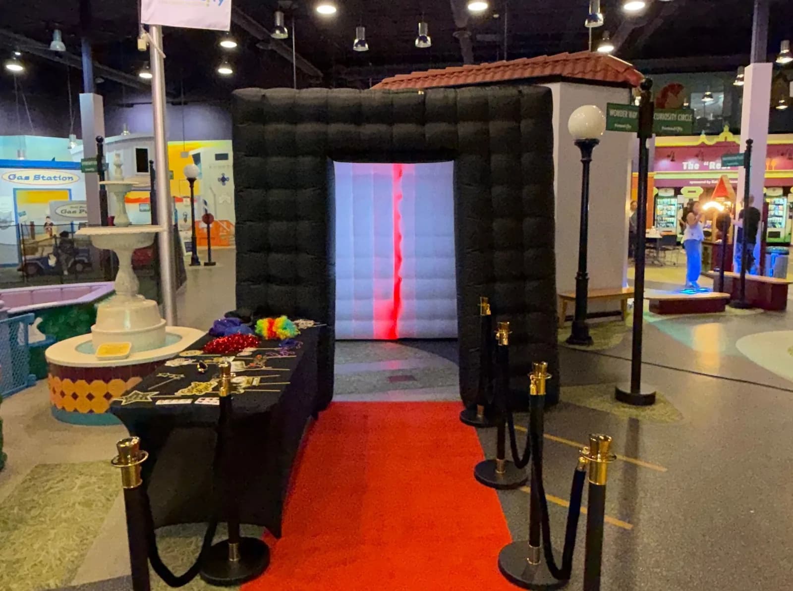 Enclosed photo booth with red carpet and stanchions