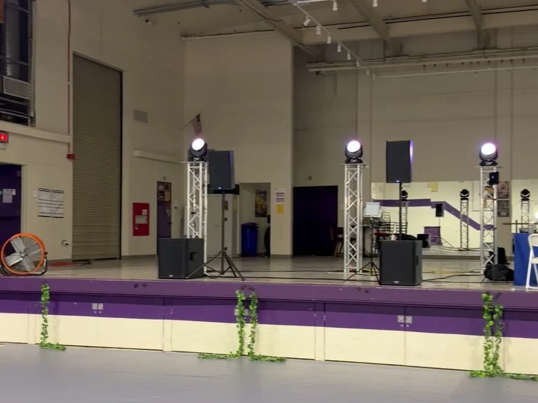 Aluminum truss totems, speakers on stands and subwoofers on a stage